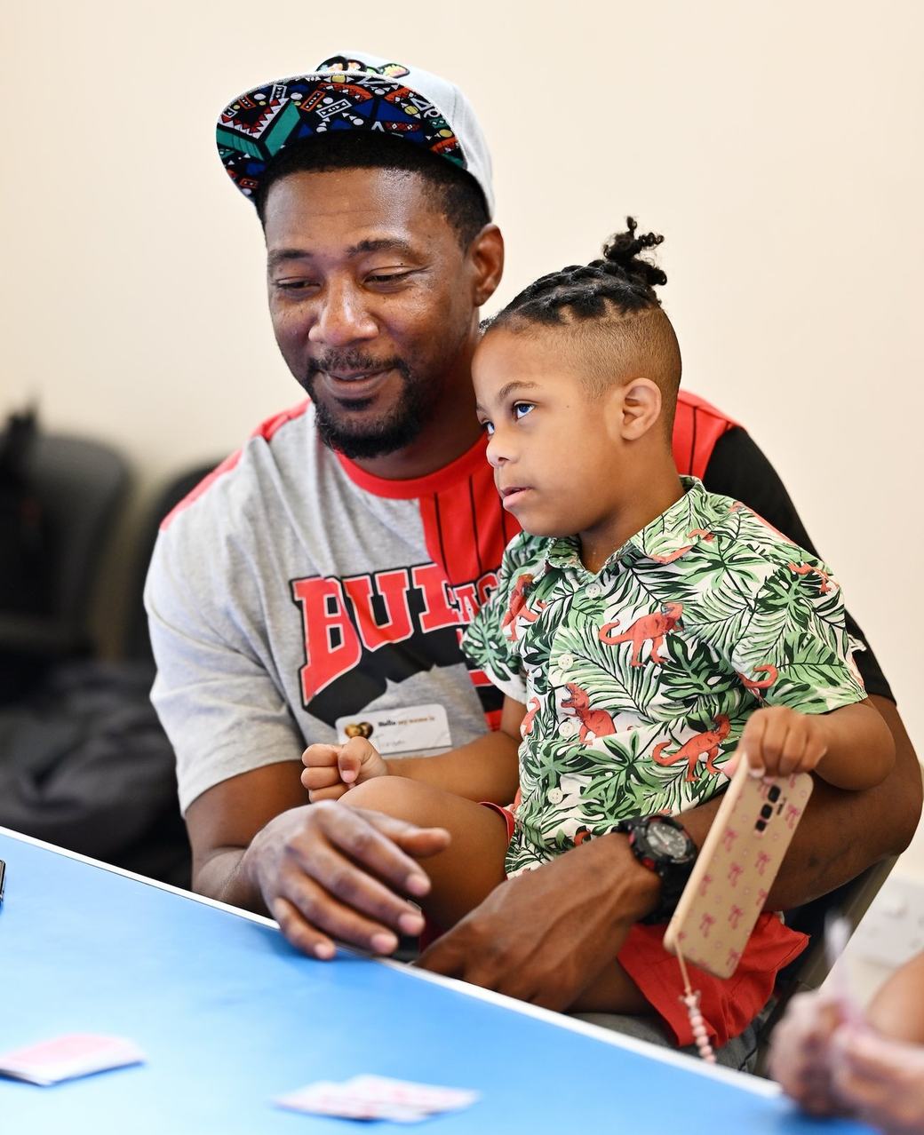 Father and young child seated together during the community event