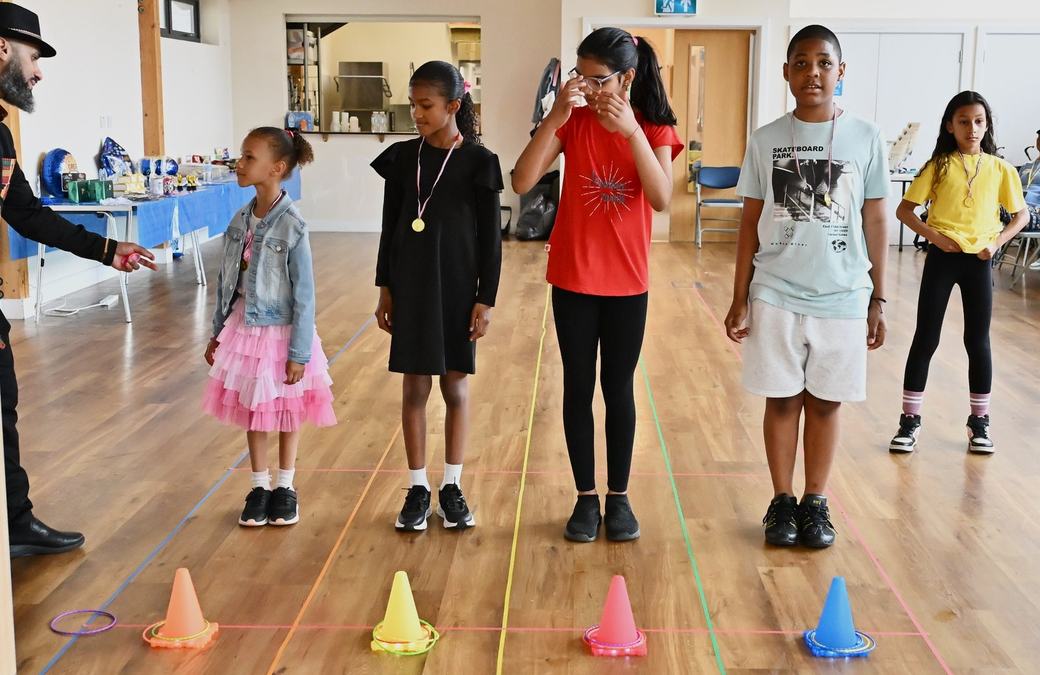 Children lined up by cones for a Father’s Day game activity