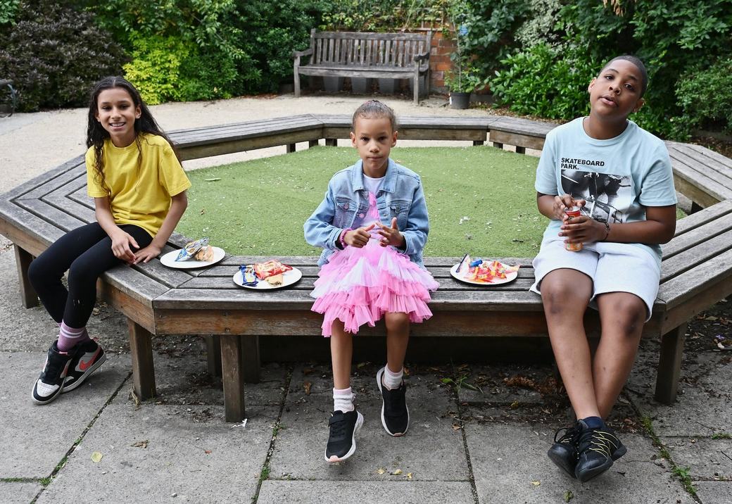 Young attendees sitting outdoors with refreshments during the Father’s Day event