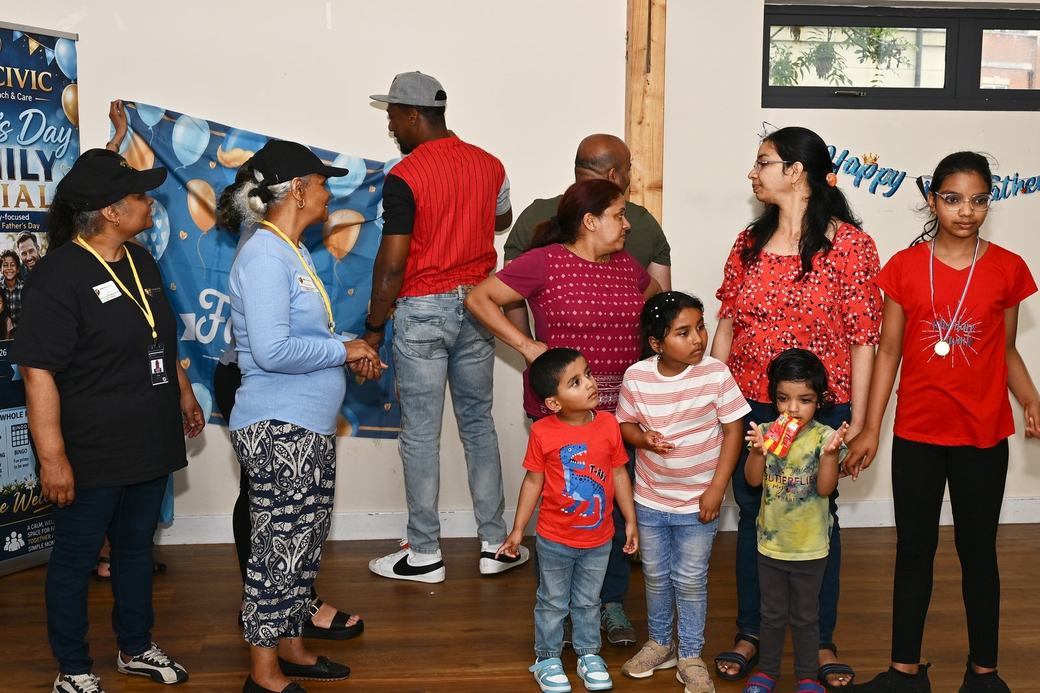Families and D’Key Civic team beside the Father’s Day photo backdrop