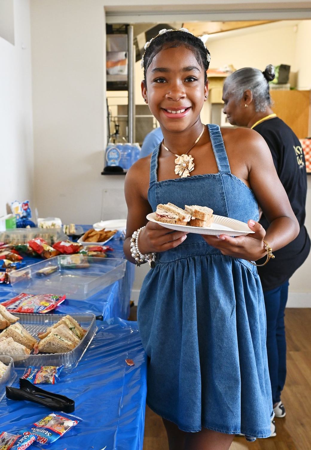 Young attendee holding a plate near the refreshments table