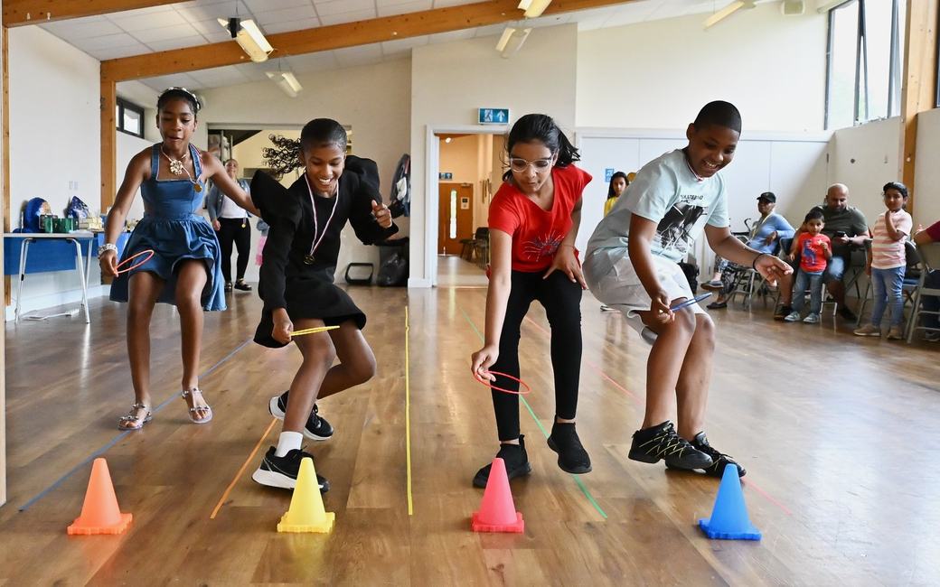 Children playing a ring toss game with cones at the Father’s Day event