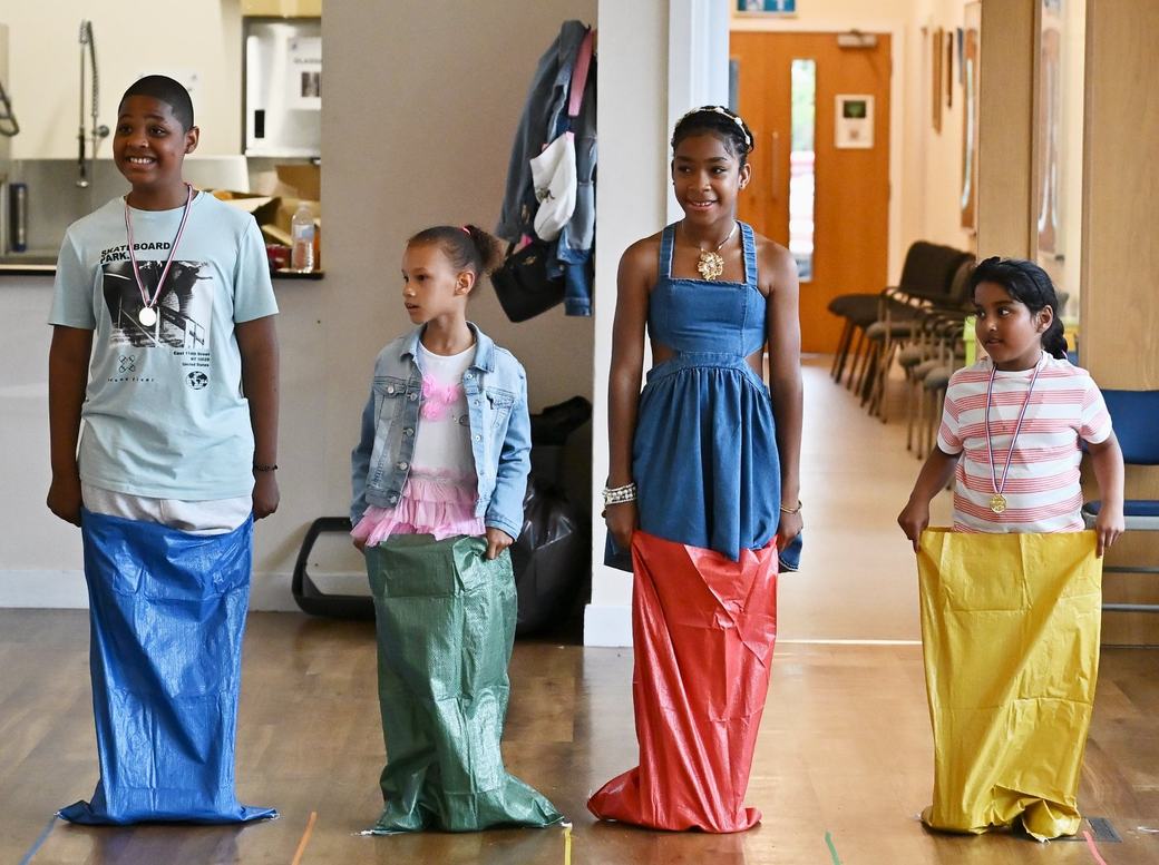 Children lined up in sacks before the sack race activity