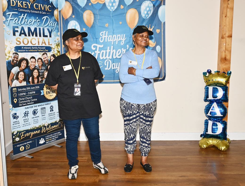 D’Key Civic team members standing beside the Father’s Day Family Social backdrop
